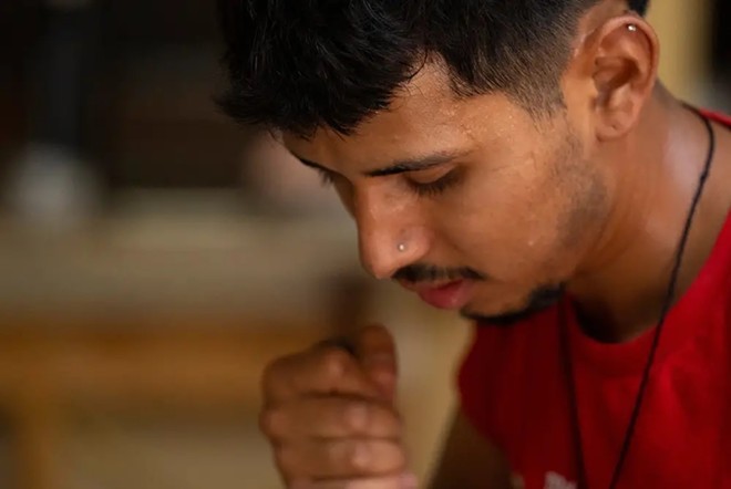 Johnny Barcenas, 24, sweats while working on renovating the floor of an Austin home on July 7, 2023. - Texas Tribune / Joe Timmerman