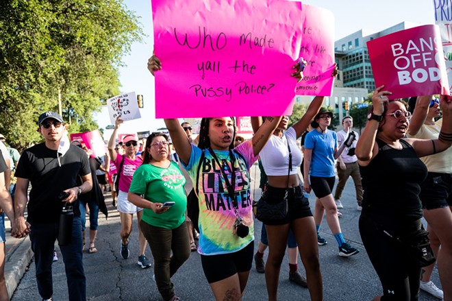 Abortion-rights protesters carry signs through downtown San Antonio on Friday. - Jaime Monzon