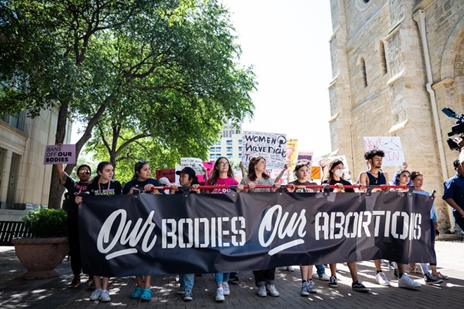 Women carry a banner through Downtown San Antonio during a protest defending abortion rights. - Jaime Monzon