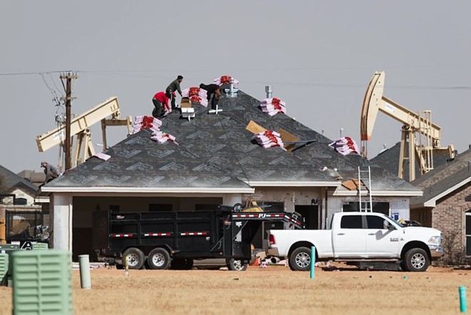 A roofing crew begins to shingle a home under construction in the Pavilion Park development in north Midland on March 14, 2022. - Texas Tribune / Eli Hartman