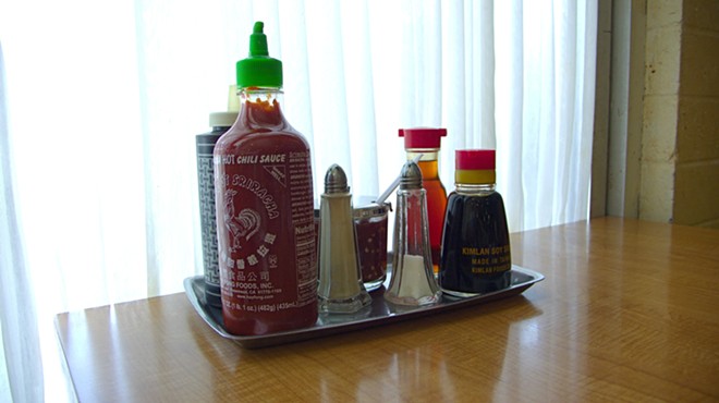 Huy Fong Food's Sriracha sits among other sauces on a tray.