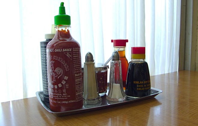 Huy Fong Food's Sriracha sits among other sauces on a tray. - Wikimedia Common