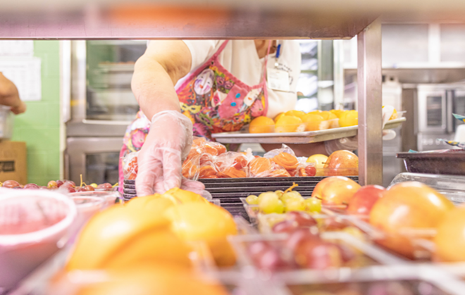 A North East ISD cafeteria employee arranges fruit on a tray. - Jason Gatell