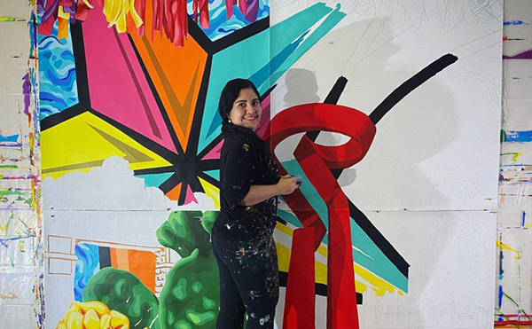 Artist Sandra Gonzalez works on a painting.