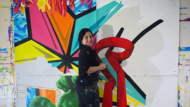 Artist Sandra Gonzalez works on a painting.